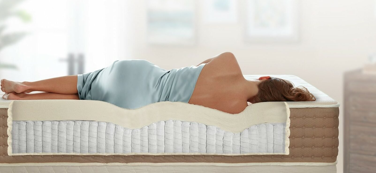 Woman lying on her side on a mattress showing how the mattress conforms well to the shape of her body