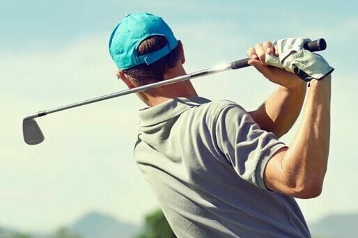 Man in the follow through phase of his golf swing
