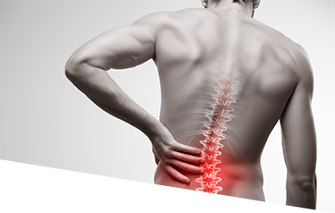 A man's back with spinal joints depicted while he clutches his low back in pain