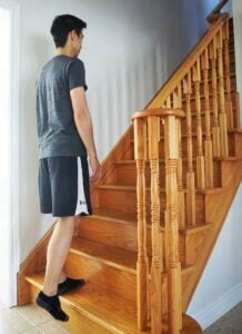 man performing a step up exercise on stairs
