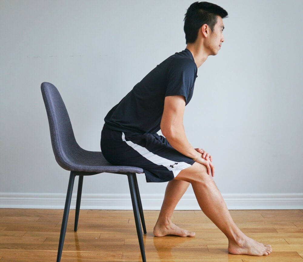 Man stretching his hamstring sitting in a chair