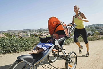 post partum woman running with baby in stroller